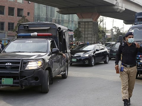 A police officer clears way for a convoy of an anti-terrorism court judge Arshad Hussain Butta arriving at district jail, where the special court setup for the trial of prime suspects in motorway gang-rape case, in Lahore, Pakistan, Saturday, March 20, 2021.    
