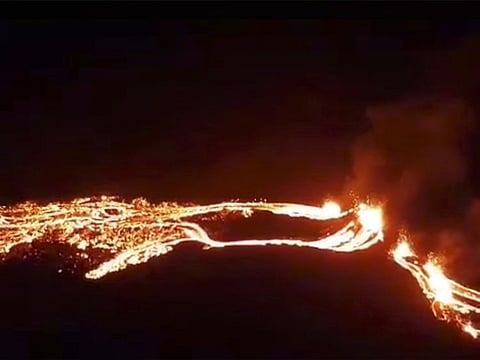 This photo provided by the Icelandic Met Office shows an eruption, center right, on the Reykjanes Peninsula in southwestern Iceland on Friday, March 19, 2021. The long dormant volcano flared to life Friday night, spilling lava down two sides in that area's first volcanic eruption in nearly 800 years. 