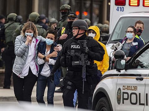 Healthcare workers walk out of a King Sooper's Grocery store after a gunman opened fire on March 22, 2021 in Boulder, Colorado. 