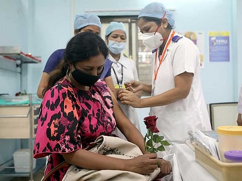 A healthcare worker holding a rose receives an AstraZeneca's COVISHIELD vaccine, during the coronavirus disease (COVID-19) vaccination campaign, at a medical centre in Mumbai, India, January 16, 2021.