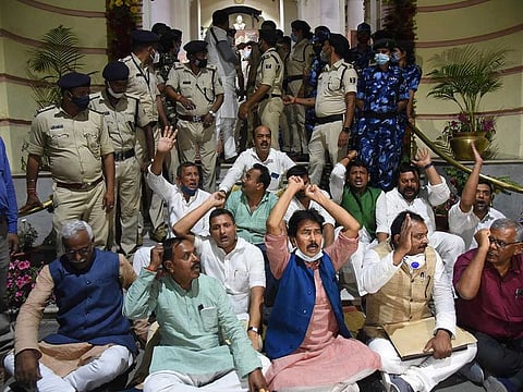 Grand Alliance legislators stage a protest in the main entrance of Bihar Assembly during the Budget session, in Patna, Tuesday, March 23, 2021.