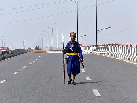 A Nihang Sikh walks on the deserted road at Ghazipur border (Delhi-UP border) in view of a 12-hour 'Bharat Bandh' call by Samyukt Kisan Morcha against Centre's Farm Laws, in New Delhi on Friday, March 26, 2021. 