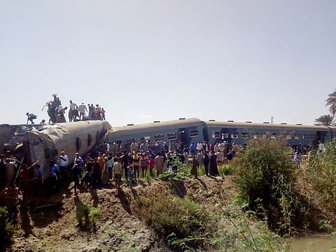 People inspect the damage after two trains collided near the city of Sohag, Egypt.