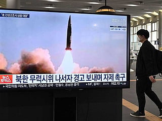 A man walks past a television screen at Suseo railway station in Seoul on March 26, 2021, showing news footage of North Korea's latest tactical guided projectile test.