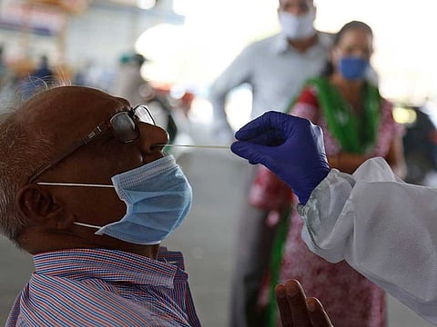 A health worker takes a nasal swab sample to test for COVID-19 in Ahmedabad, India, Friday, March 26, 2021. 
