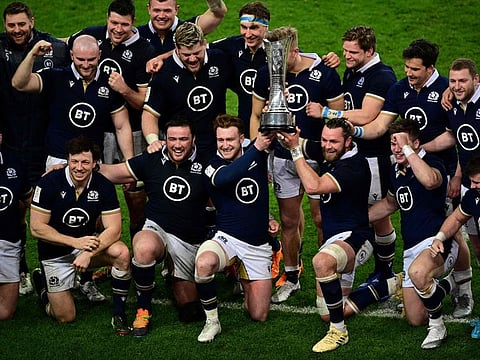 Scotland players pose with the  Auld Alliance Trophy after winning the  Six Nations Rugby Union game against France on Friday. Scotland's mean, meanwhile, ensured the title for Wales - who have now won their second Six Nations in three years.
