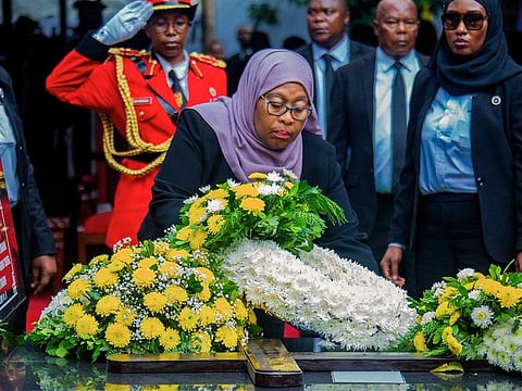 President Samia Suluhu Hassan places flowers on the grave of former President John Magufuli in his home town of Chato, Tanzania Friday, March 26, 2021.