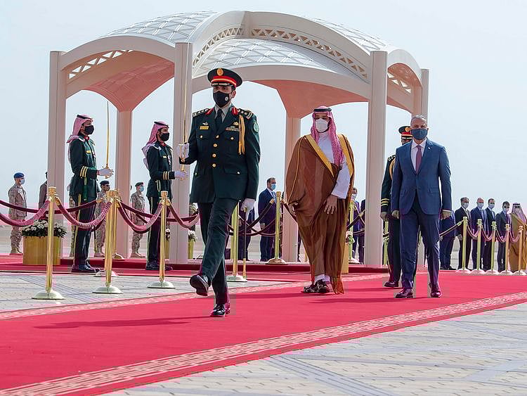 In this photo released by Saudi Royal Palace, Saudi Crown Prince Mohammed bin Salman, second right, accompanies Iraqi Prime Minister Mustafa Al Kadhimi upon his arrival at Riyadh international airport, Saudi Arabia, March 31, 2021. 