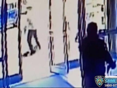 A person of interest, background center, assaulting an Asian American woman, on ground.