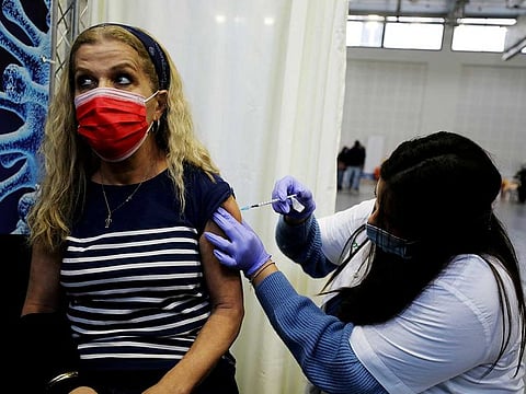 A woman receives a vaccination against COVID-19 at a temporary Clalit healthcare maintenance organisation (HMO) centre, at a basketball court in Petah Tikva, Israel January 28, 2021. 