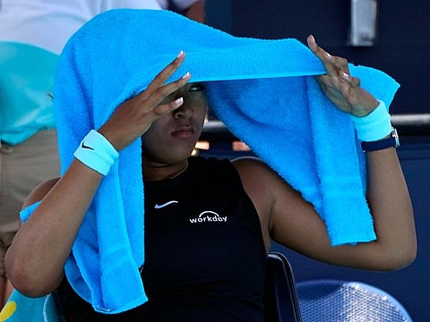Naomi Osaka looks out from under a towel during her quarter final against Maria Sakkari at the Miami Open on Wednesday. Sakkari won 6-0, 6-4. 