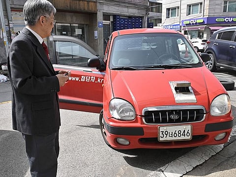 Retired South Korean professor Han Min-hong looking at his 21-year-old self-driving car in front of his office in Yongin, south of Seoul.