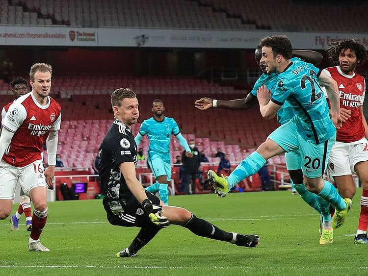 Liverpool's Diogo Jota, right, scores his sides third goal past Arsenal's goalkeeper Bernd Leno 