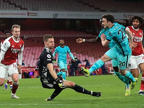 Liverpool's Diogo Jota, right, scores his sides third goal past Arsenal's goalkeeper Bernd Leno 