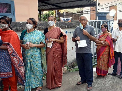 Voters stand in the queue to cast their ballots at a polling booth during the Kerala Assembly election, in Thiruvananthapuram on Tuesday, April 6, 2021. 
