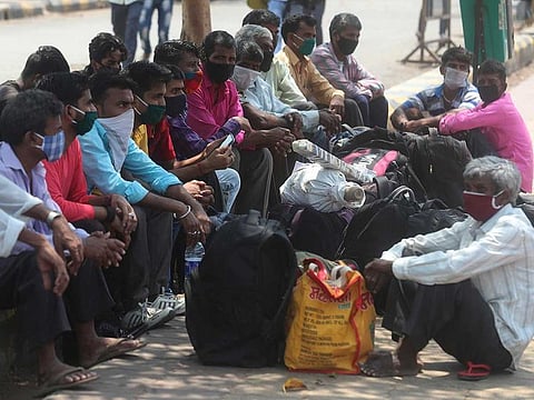 Migrant workers from Bihar state wearing face masks wait for a train at Lokmanya Tilak train station in Mumbai, India, Wednesday, April 7, 2021. 