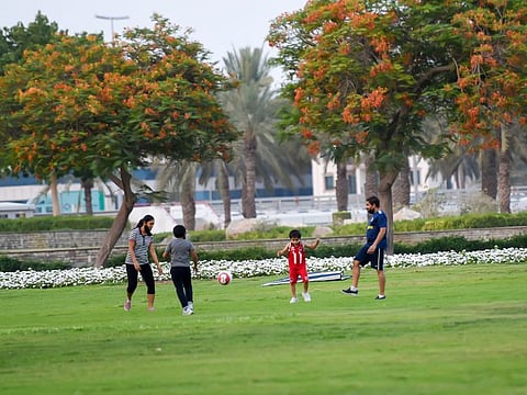 Family members playing outside Zabeel park in the evening.