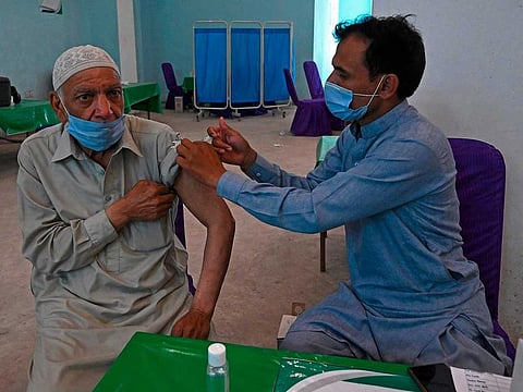 A senior citizen receives a doze of the Chinese-made Sinopharm vaccine against the COVID-19 coronavirus at a vaccination centre in Lahore on April 4, 2021. 