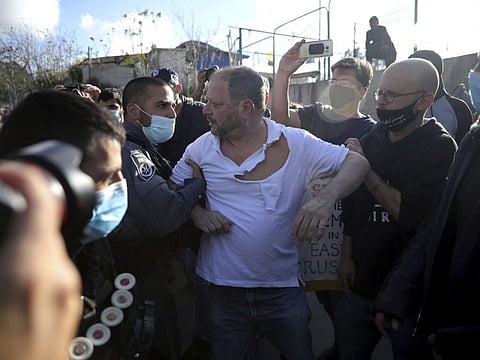 Police scuffle with Ofer Cassif, the only Jewish member of the Joint List, an alliance of Arab parties in Israel's Knesset, during a protest against planned evictions in east Jerusalem on Friday, April 9, 2021. 