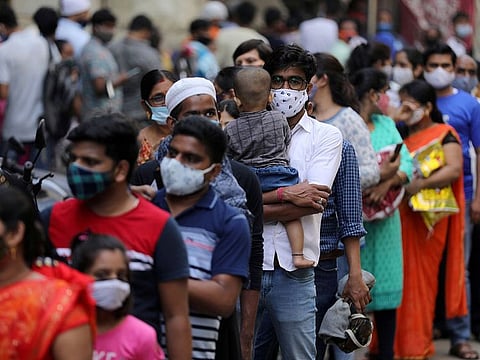 People wait in a line to enter a supermarket amidst the spread of COVID-19 in Mumbai, India