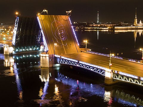 A portrait of Yuri Gagarin is projected by laser onto the Dvortsovy (Palace) drawbridge rising above the Neva River during a celebration of the 60th anniversary of Russia's Yuri Gagarin's first manned flight into space, in St. Petersburg, Russia, early Monday, April 12, 2021.