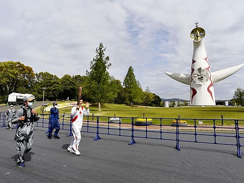 Former Japanese backstroke swimmer Aya Terakawa, a Tokyo 2020 Olympic torch relay runner, runs at the Expo '70 Commemorative Park without spectators instead of on public roads due to the coronavirus disease (COVID-19) outbreak in Osaka, western Japan April 13, 2021,