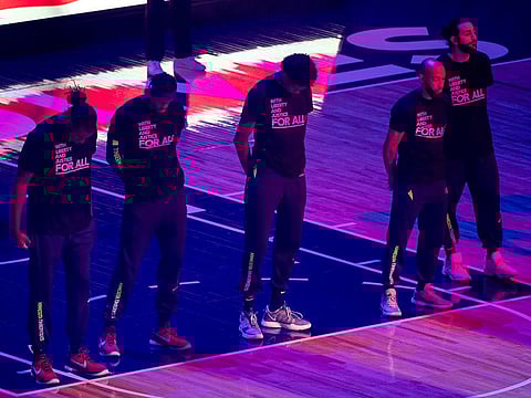 Members of the Minnesota Timberwolves, pictured, and the Brooklyn Nets wear T-shirts that read 'With liberty and justice for all' as a tribute to Daunte Wright, before an NBA basketball game Tuesday.