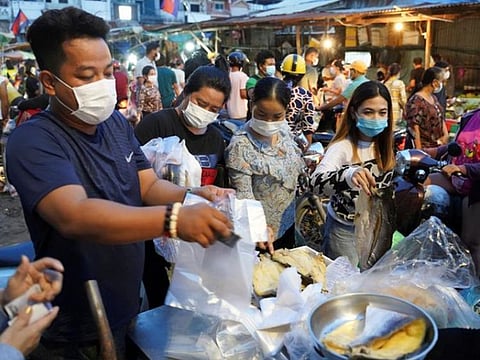 People wearing protective face masks rush to buy groceries at a fresh market ahead of a citywide lockdown during the latest coronavirus disease (COVID-19) outbreak in Phnom Penh, Cambodia.