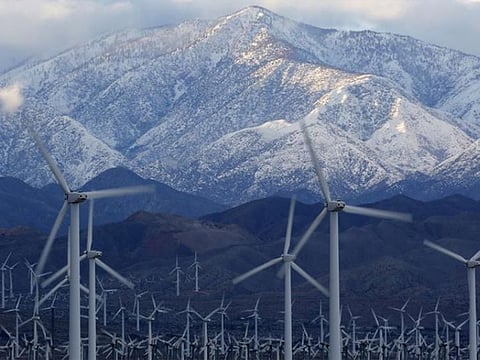 Snow is seen on the San Gorgonio Mountains behind a windmill farm in Palm Springs, California.