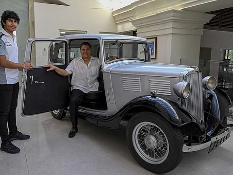 Galle Face Hotel chairman Sanjeev Gardiner (R) and his son Seshaan pose with the 1935 Standard Nine vintage car which is claimed to be owned and the first car of Prince Philip (not pictured) now acquired by the Gardiner family in Colombo on April 14, 2021. 