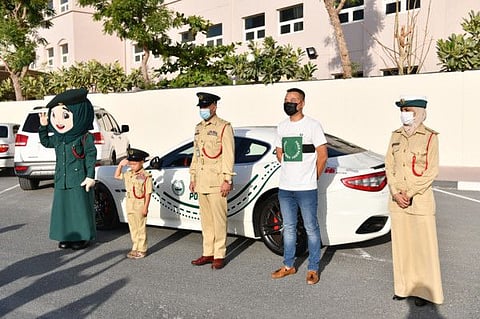 Lucas Li Chao with Dubai Police officials and the Dubai Police mascot.