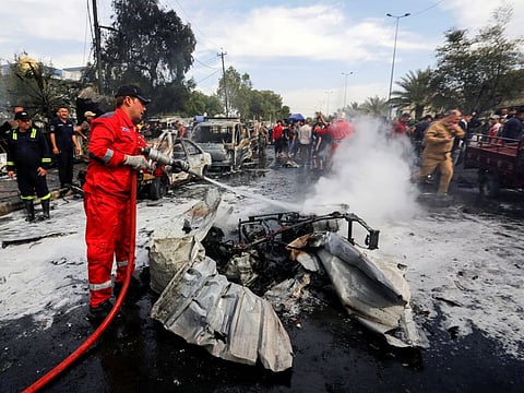 A firefighter inspects the site of a car bomb attack in Sadr City district of Baghdad, Iraq April 15, 2021. 