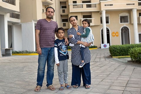 Ashish Anand and his wife, Akanksha Chadda, with their children, Rehan, 8, and Gunika, 4, outside their home in Noida, India, on March 31, 2021. 