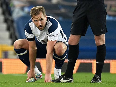Tottenham Hotspur striker Harry Kane holds his foot before leaving the pitch injured against Everton