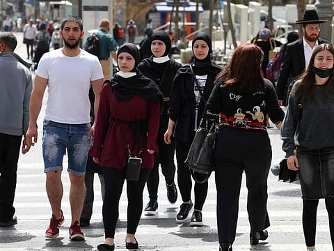 People walk on a street in Jerusalem in a file photo. The highly contagious Omicron variant of the coronavirus peaked in Israel towards the end of January with daily cases reaching record highs of some 85,000, but numbers have steadily declined since to around 21,000 by Wednesday.