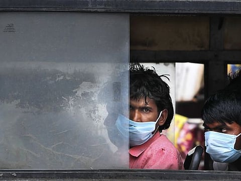 Migrant laborers sit in a bus to travel to their villages following a lockdown put into place to control the rising cases of coronavirus infections, in New Delhi, India, Tuesday, April 20, 2021