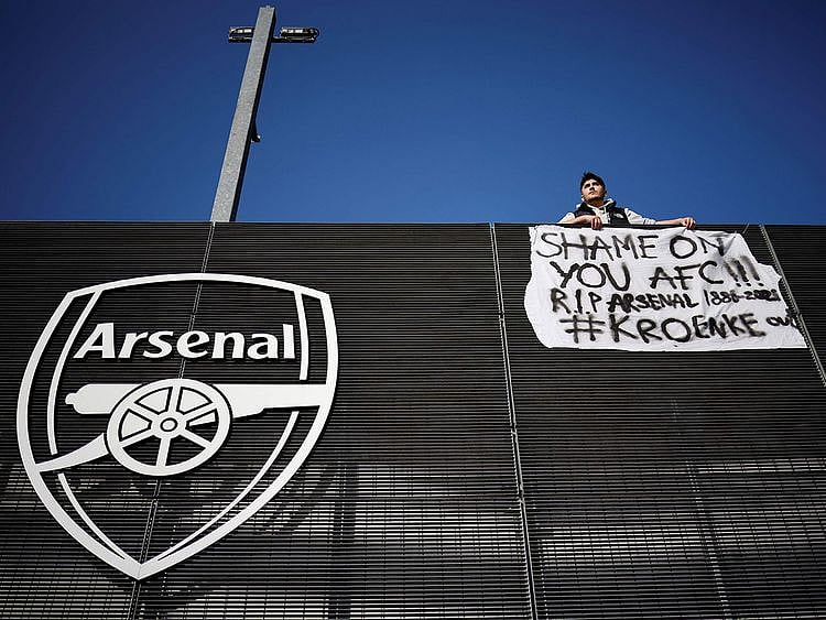 An Arsenal fan stands with his anti-European Super League banner outside the Emirates Stadium on April 19, 2021.