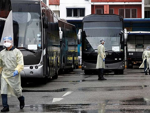 Buses stand by to transport migrant workers to a government quarantine facility after workers were tested positive for the coronavirus disease (COVID-19) at Westlite Woodlands dormitory in Singapore April 22, 2021. 