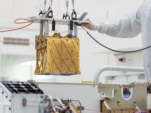 Technicians at NASA's Jet Propulsion Laboratory lower the Mars Oxygen In-Situ Resource Utilization Experiment (MOXIE) instrument into the belly of the Perseverance rover in an undated photograph in Pasadena, California, U.S. 