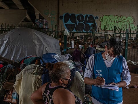 Public health agents distribute masks and other hygiene supplies for people experiencing homelessness in Sao Paulo, Brazil, on Thursday, April 22, 2021.
