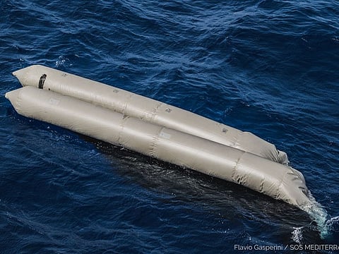 A rubber boat is seen after having capsized with more than 100 migrants on board, during a search and rescue (SAR) operation in the Mediterranean Sea, off the Libyan Coast.