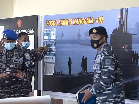 Members of the Indonesian military officials install a picture of the Indonesian Navy submarine KRI Nanggala that went missing while participating in a training exercise on Wednesday, at a command at Ngurah Rai Airport, Bali, Indonesia.