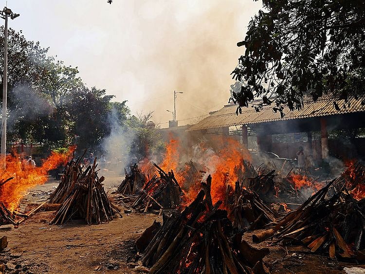 Funeral pyres of COVID-19 fatalities burn at a crematorium in New Delhi