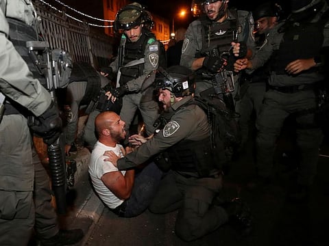 A Palestinian protester is detained during clashes with Israeli police, as the Muslim holy fasting month of Ramadan continues, in Jerusalem, April 23, 2021. 