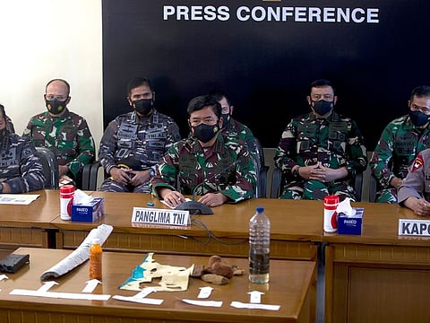 Indonesian Navy Chief Yudo Margono, front left, Indonesian Military chief Hadi Tjahjanto, center, and Indonesia police chief Listyo Sigit Prabowo, right, talk to media as they display debris found in the waters during a search for the Indonesian Navy submarine KRI Nanggala at Ngurah Rai Military Air Base in Bali, Indonesia