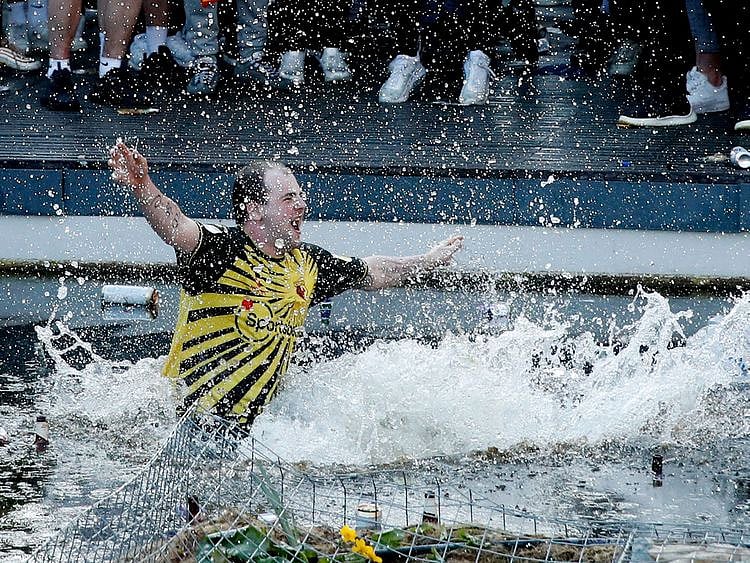 A Watford fan jumps into a fountain after his club sealed promotion to the Premier League 