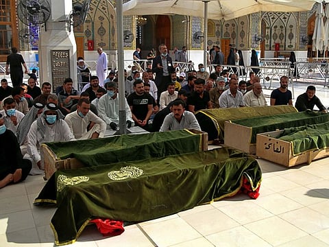 Mourners pray near the coffins of coronavirus patients who were killed in a hospital fire, during their funeral at the Imam Ali shrine in Najaf, Iraq, Sunday, April 25, 2021. Iraq's Interior Ministry said Sunday that over 80 people died and over 100 were injured in a catastrophic fire that broke out in the intensive care unit of a Baghdad hospital tending to severe coronavirus patients. 