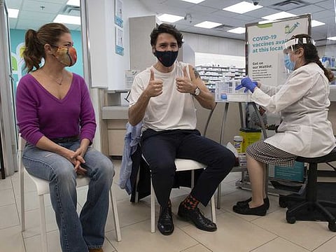 Justin Trudeau, Canada's prime minister, gives a thumbs up before receiving a dose of the AstraZeneca COVID-19 vaccine with his wife Sophie Grgoire Trudeau, left, in Ottawa, Ontario, Canada, on Friday, April 23, 2021.