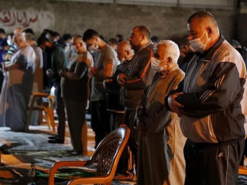 People pray the evening prayer during the Muslim holy fasting month of Ramadan outside a mosque in Gaza City.