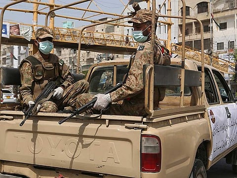 Army troops patrol a market to observe new restrictions announced by government to help control the spread of the coronavirus in Karachi, Pakistan, Tuesday, April 27, 2021. 